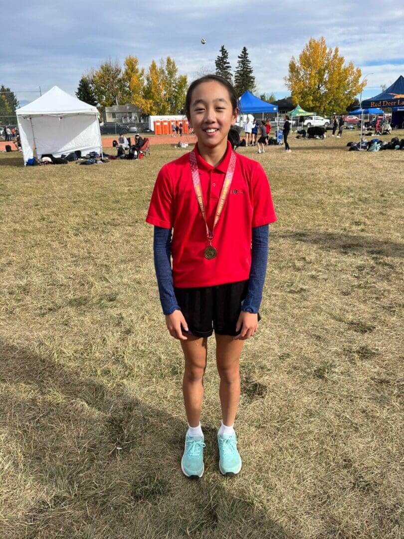 Smiling young runner wearing medal outdoors