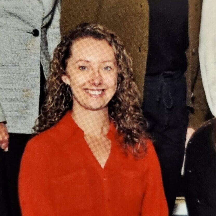 Smiling woman with curly hair wearing red blouse
