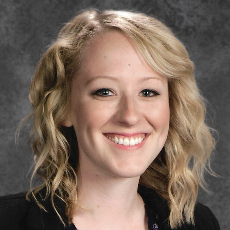 Smiling woman with blonde wavy hair.