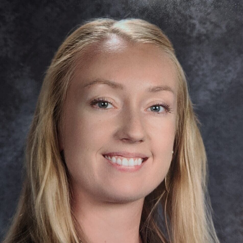 Smiling blonde woman headshot on gray backdrop