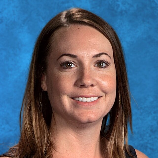 Here's an alt tag for the image: Smiling woman, headshot, teacher portrait.