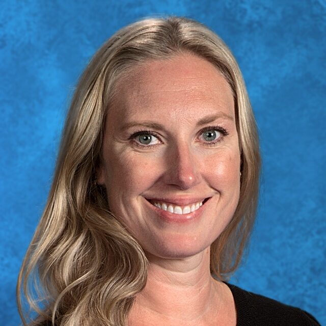 Woman with long blonde hair smiling.
