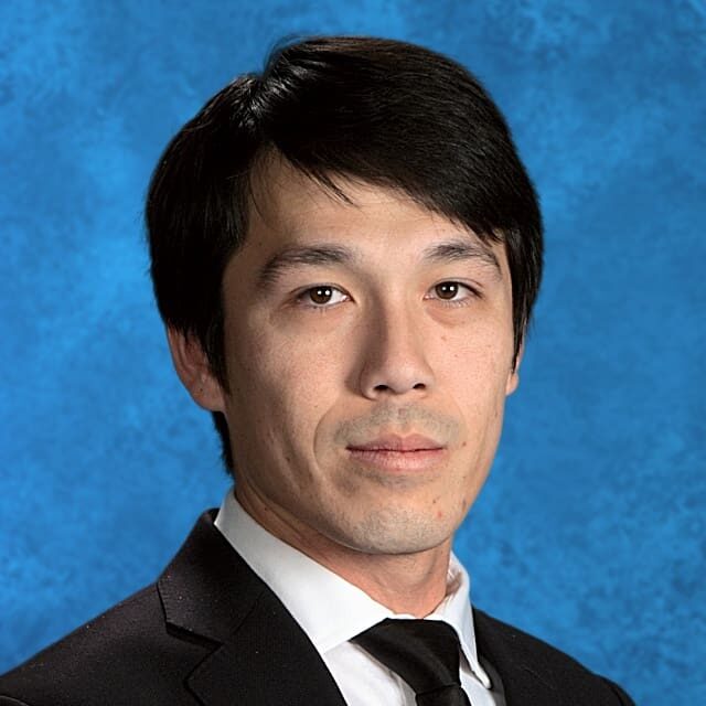 Here's an alt tag for the image: Man in suit, headshot.